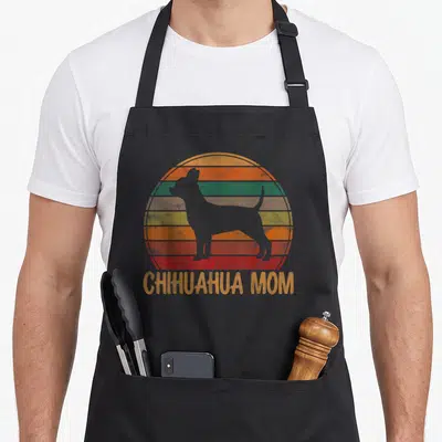Chihuahua mother's apron - White chihuahua silhouette over retro striped sun with CHIHUAHUA MOM text — shown on a black cotton canvas apron against a white background