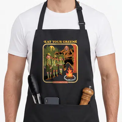 Steven dark green apron - Bigfoot looming behind three scouts with Eat Your Greens text — shown on a black cotton canvas apron against a white background