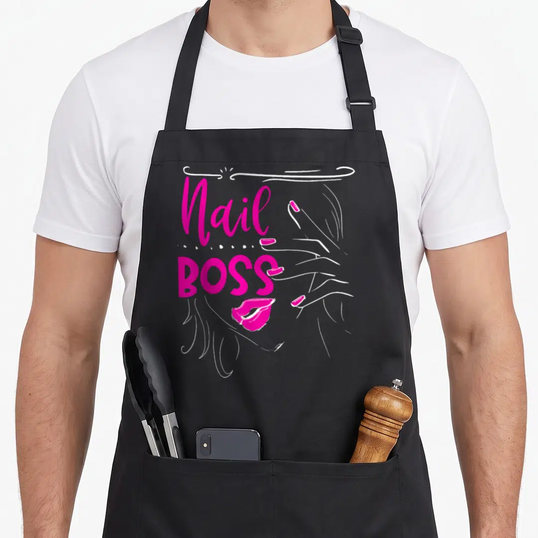 Artist manicurist apron - Nail BOSS magenta text with white line-art hand and lips illustration — shown on a black cotton canvas apron against a white background