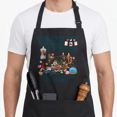 Sew us aprons - Vintage sewing machine illustration with teal lyrics and sewing tools like a dress form and pincushion — shown on a black cotton canvas apron against a white background