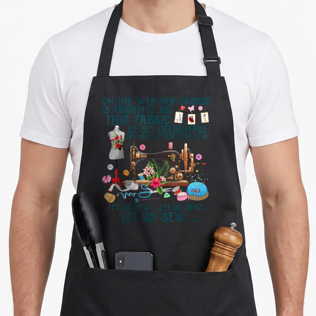 Sew us aprons - Vintage sewing machine illustration with teal lyrics and sewing tools like a dress form and pincushion — shown on a black cotton canvas apron against a white background