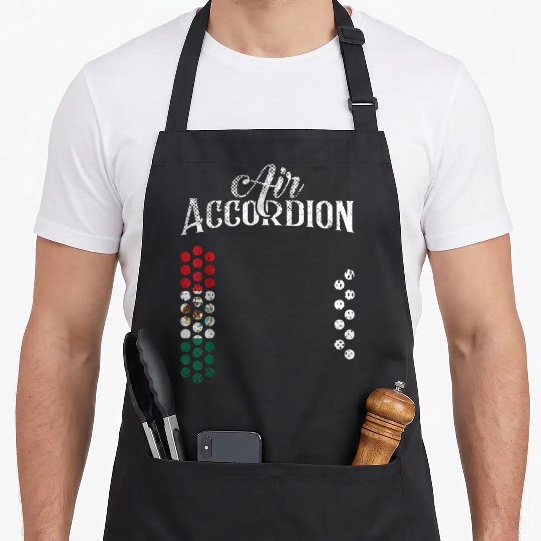 Flag mexican apron - Air ACCORDION text above red white and green button columns mimicking instrument keys — shown on a black cotton canvas apron against a white background