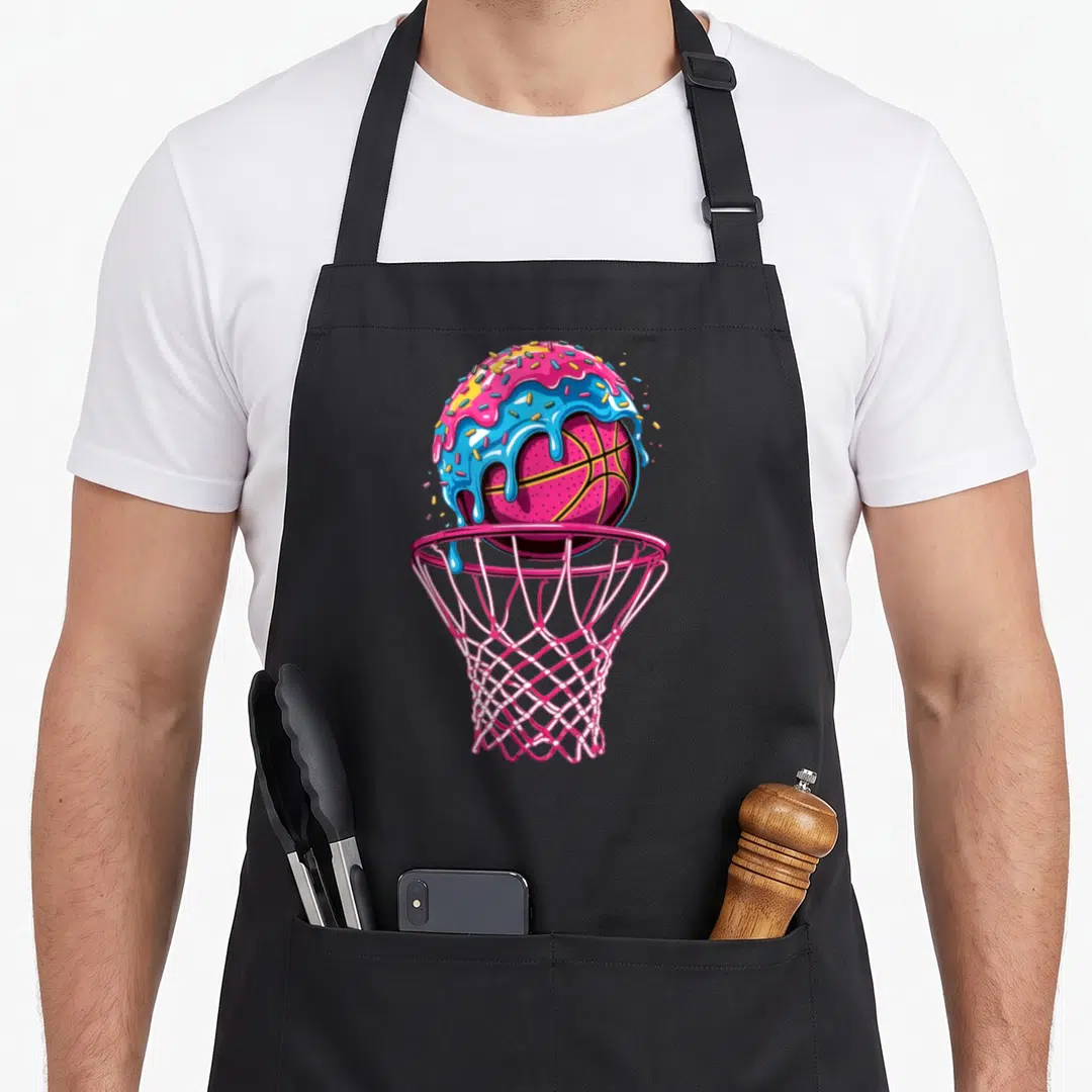 Drip sprinkle ice cream apron - Pink basketball with blue frosting and sprinkles inside a pink hoop — shown on a black cotton canvas apron against a white background