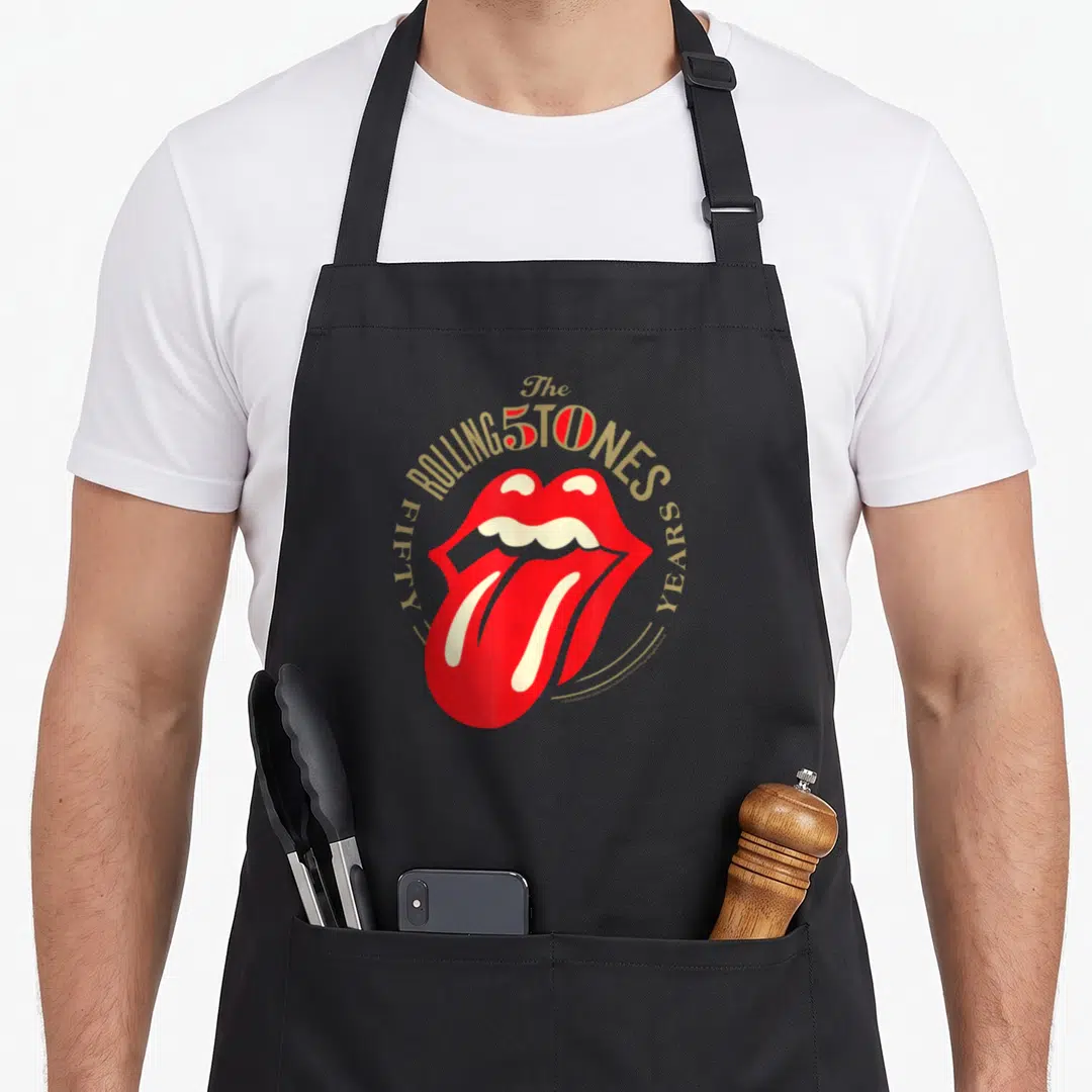 Tongue rolling stones apron for women - Red lips and gold Fifty Years text arranged in a circle around the center — shown on a black cotton canvas apron against a white background
