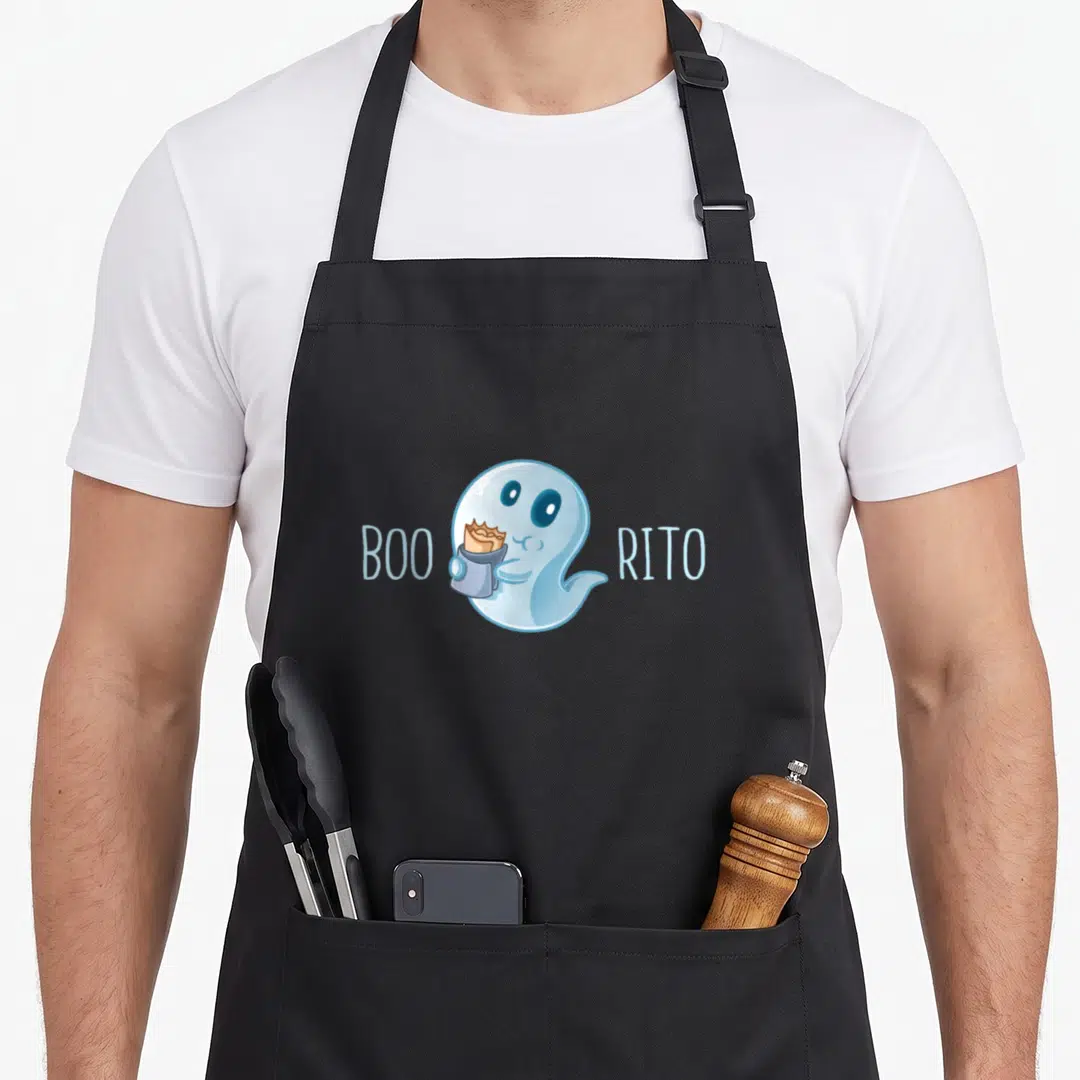 Boo mexico apron - Cartoon blue ghost holding tan burrito flanked by BOO and RITO text — shown on a black cotton canvas apron against a white background