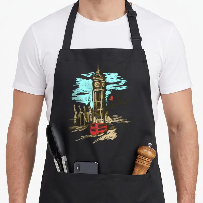Ben london aprons - Big Ben clock tower with red bus, grey car, red heart, and blue clouds in line art style — shown on a black cotton canvas apron against a white background