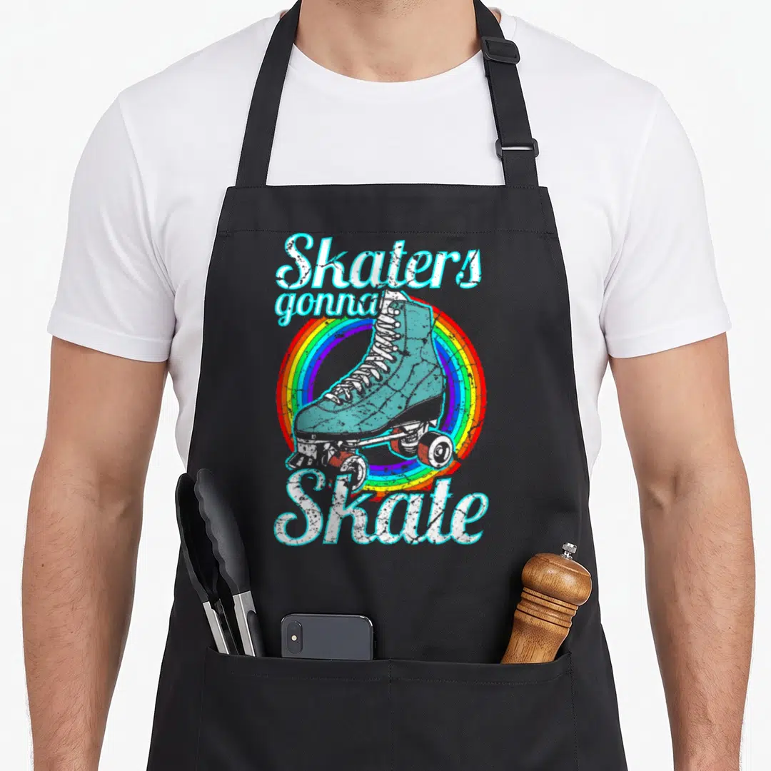 Skater disco seventies apron - Retro blue roller skate on rainbow circle with white arched text reading Skaters gonna — shown on a black cotton canvas apron against a white background