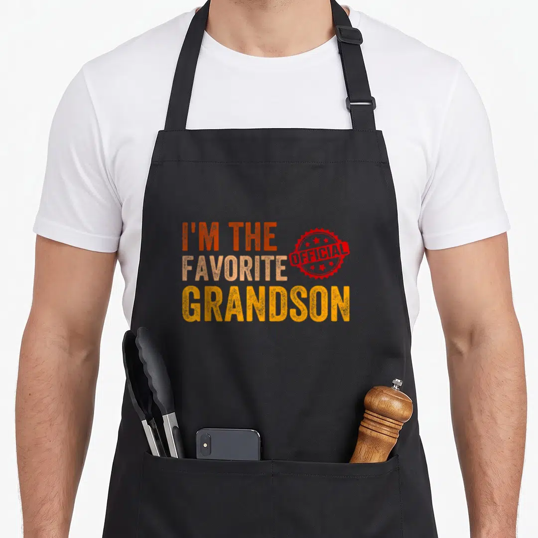 Grandson grandchild apron - Stacked text I'm the favorite grandson with red official seal stamp — shown on a black cotton canvas apron against a white background
