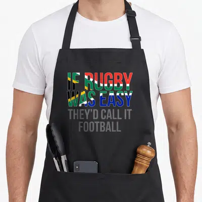 Africa rugby south african apron - Stacked text reading IF RUGBY WAS EASY THEY'D CALL IT FOOTBALL in South African flag — shown on a black cotton canvas apron against a white background