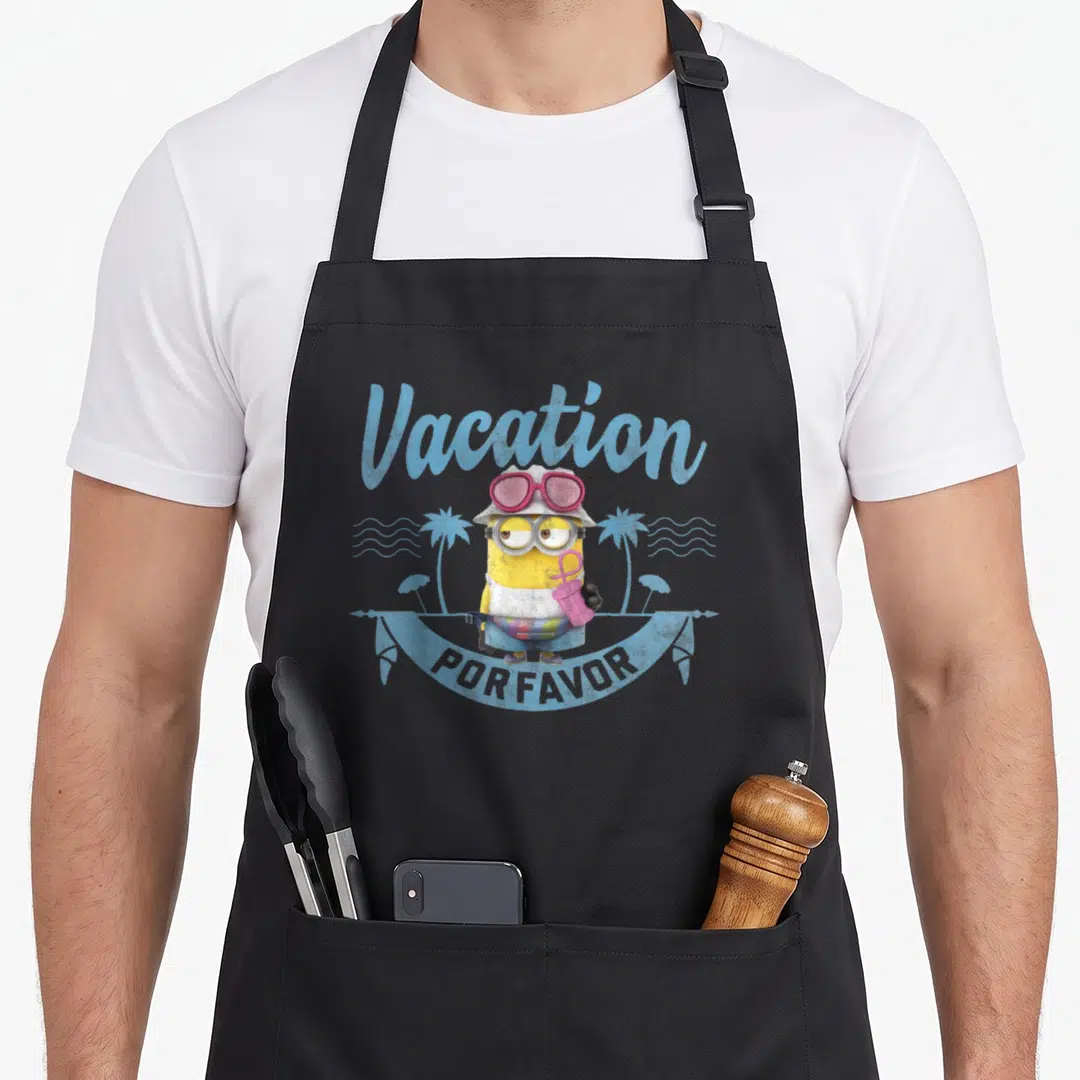 Vacation general apron - Yellow Minion with pink sunglasses holding drink under Vacation Por Favor text — shown on a black cotton canvas apron against a white background
