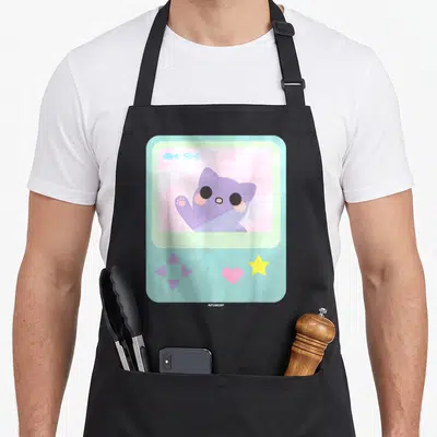 Kitty anime cooking apron - Purple cat waving inside light blue game console with pink heart and yellow star — shown on a black cotton canvas apron against a white background