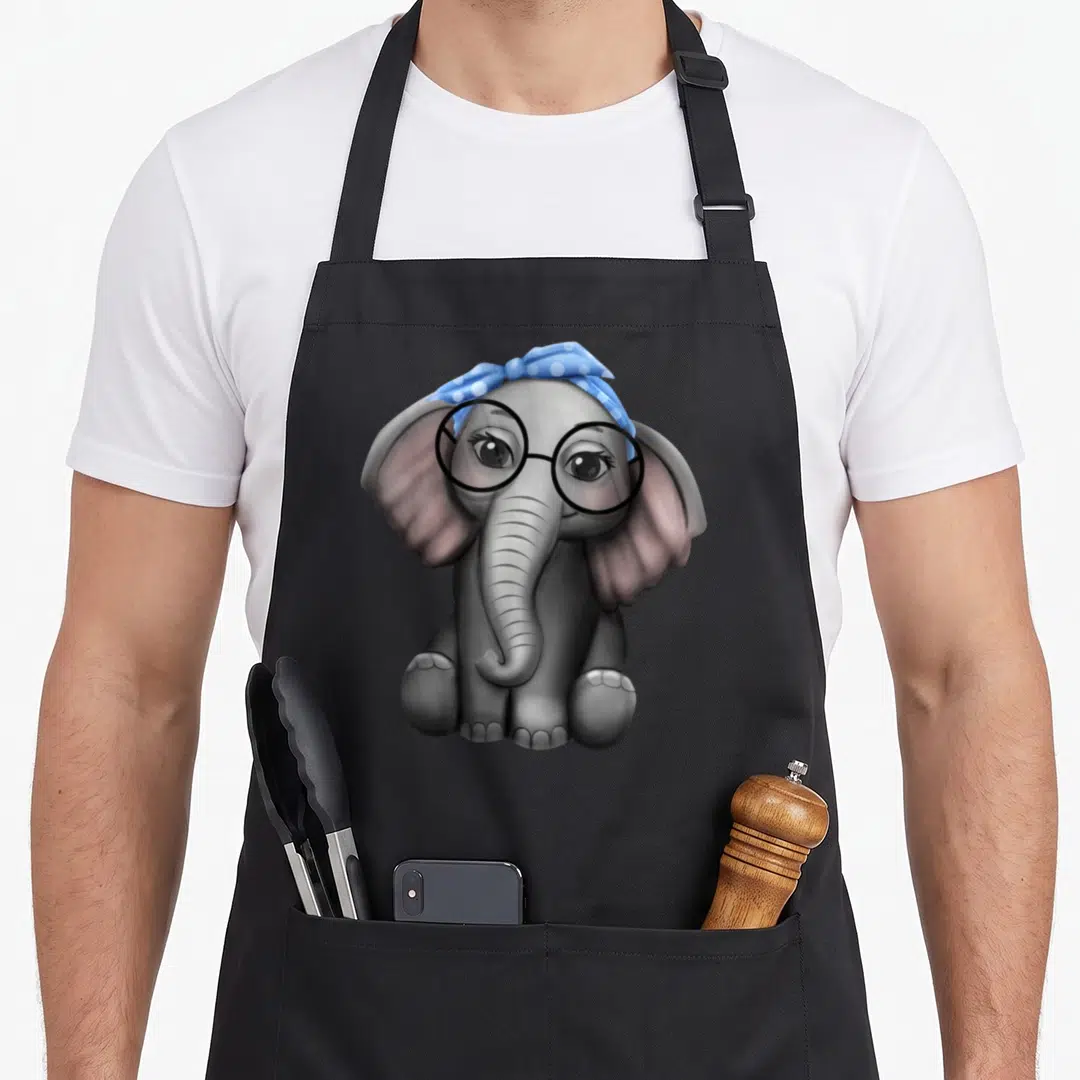 Elephant nerd apron - Cartoon grey elephant wearing black glasses and blue polka dot headband — shown on a black cotton canvas apron against a white background