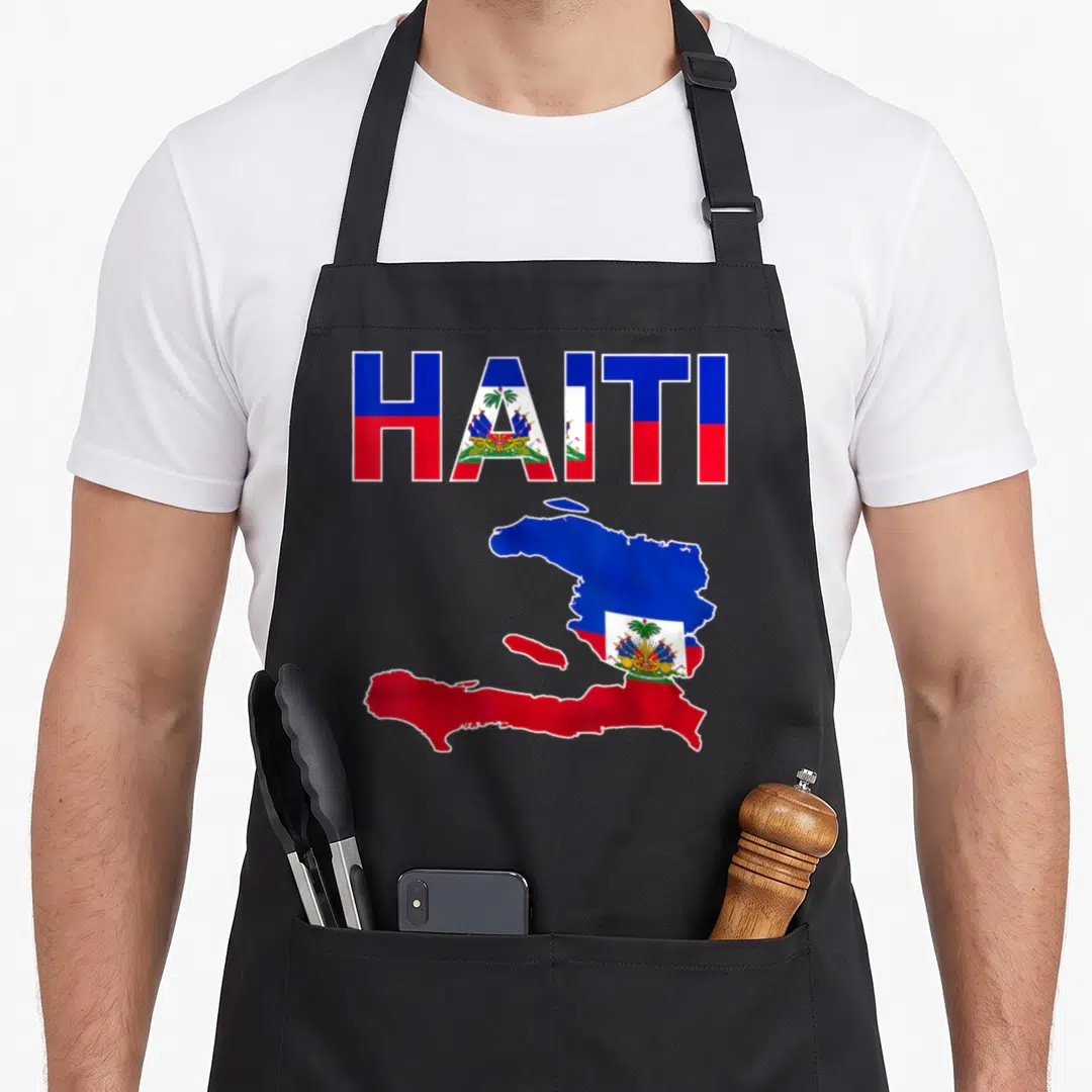 Haitian flag pride apron - HAITI text and map filled with blue red white flag pattern and coat of arms — shown on a black cotton canvas apron against a white background