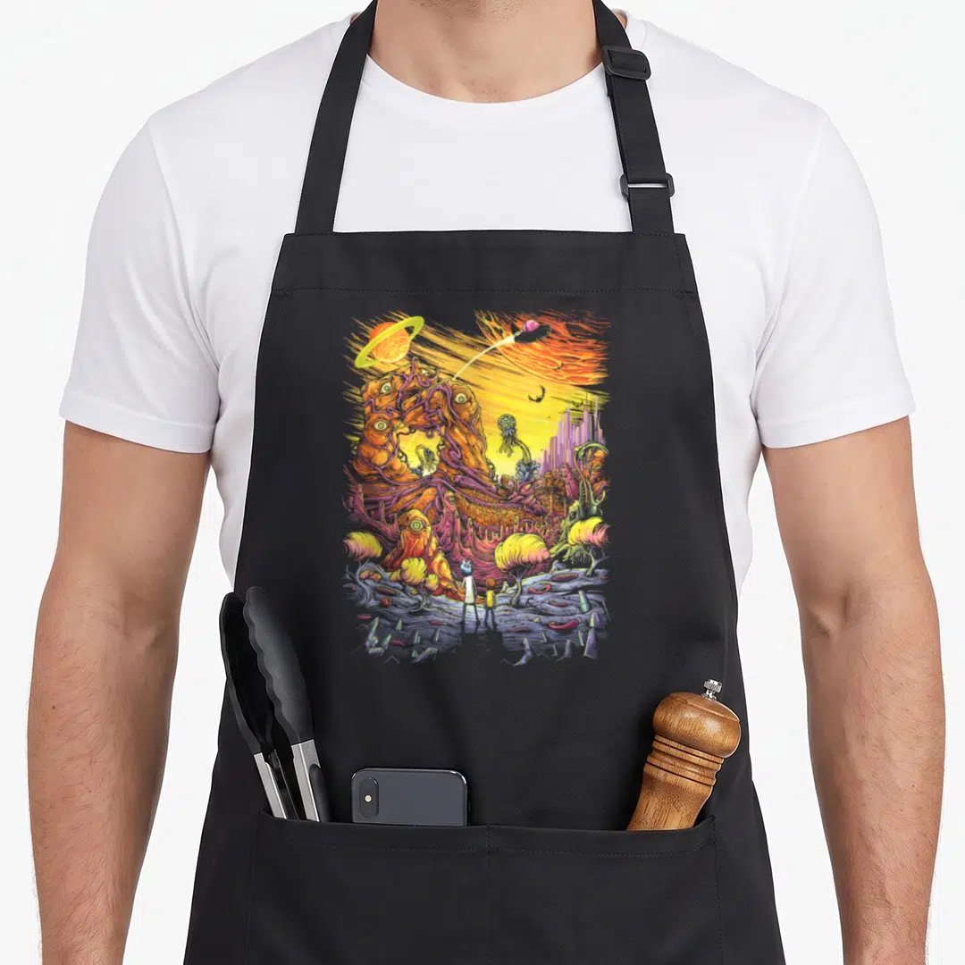 Alien general apron - Surreal alien landscape with two figures, organic eye-structure, planets, comet in orange purple — shown on a black cotton canvas apron against a white background