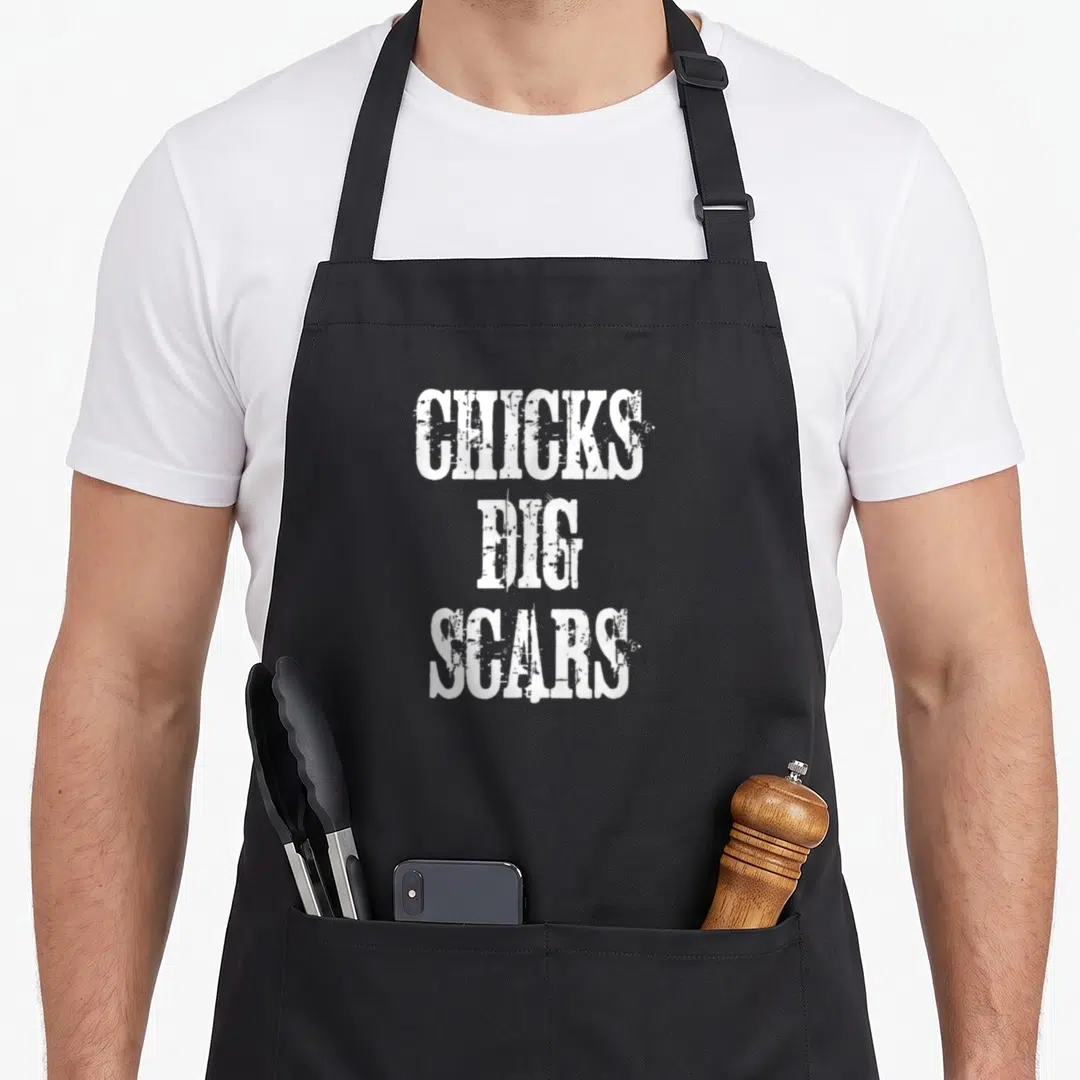 Chick congenital heart defect apron - White stacked text reading Chicks Dig Scars in distressed font — shown on a black cotton canvas apron against a white background
