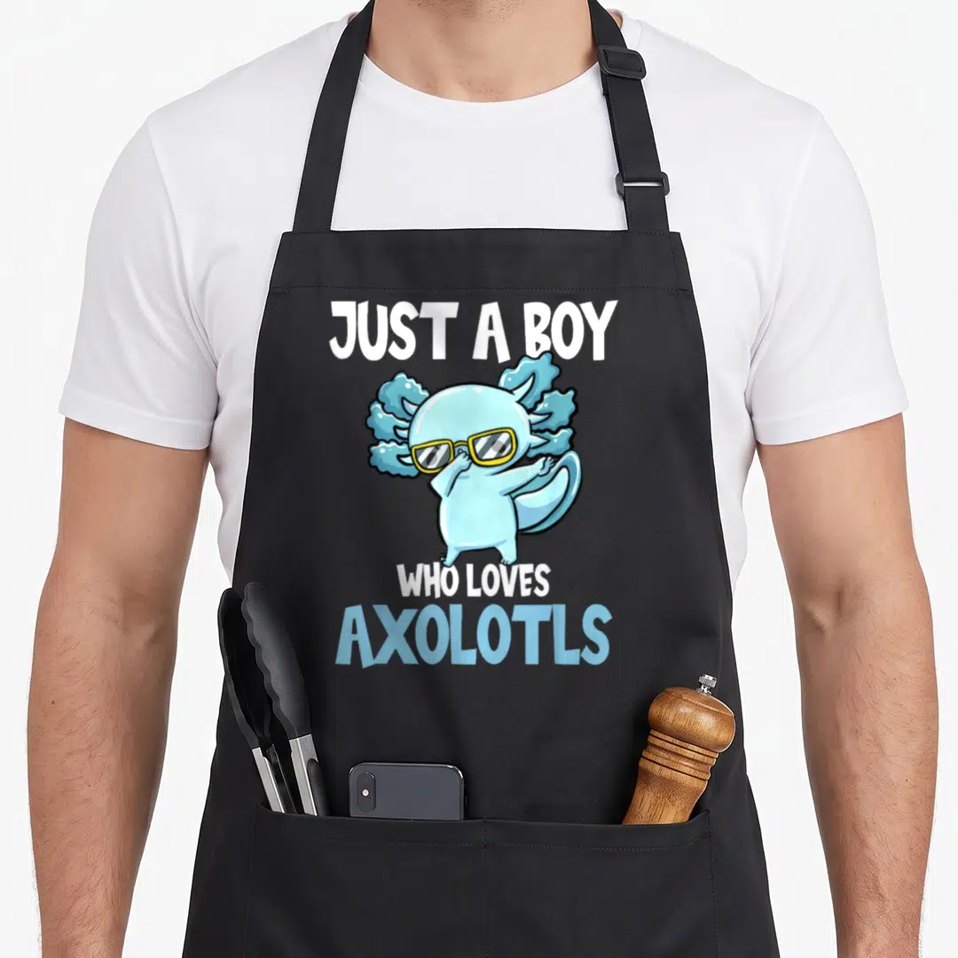Funny axolotl lover apron - Blue cartoon axolotl wearing yellow sunglasses with white and blue text reading just a boy — shown on a black cotton canvas apron against a white background
