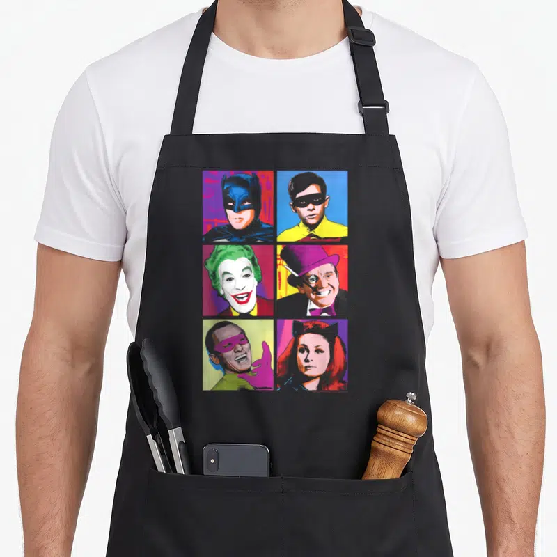 Pop tv apron - Six character portraits in a 3x2 grid of colorful squares in retro style — shown on a black cotton canvas apron against a white background