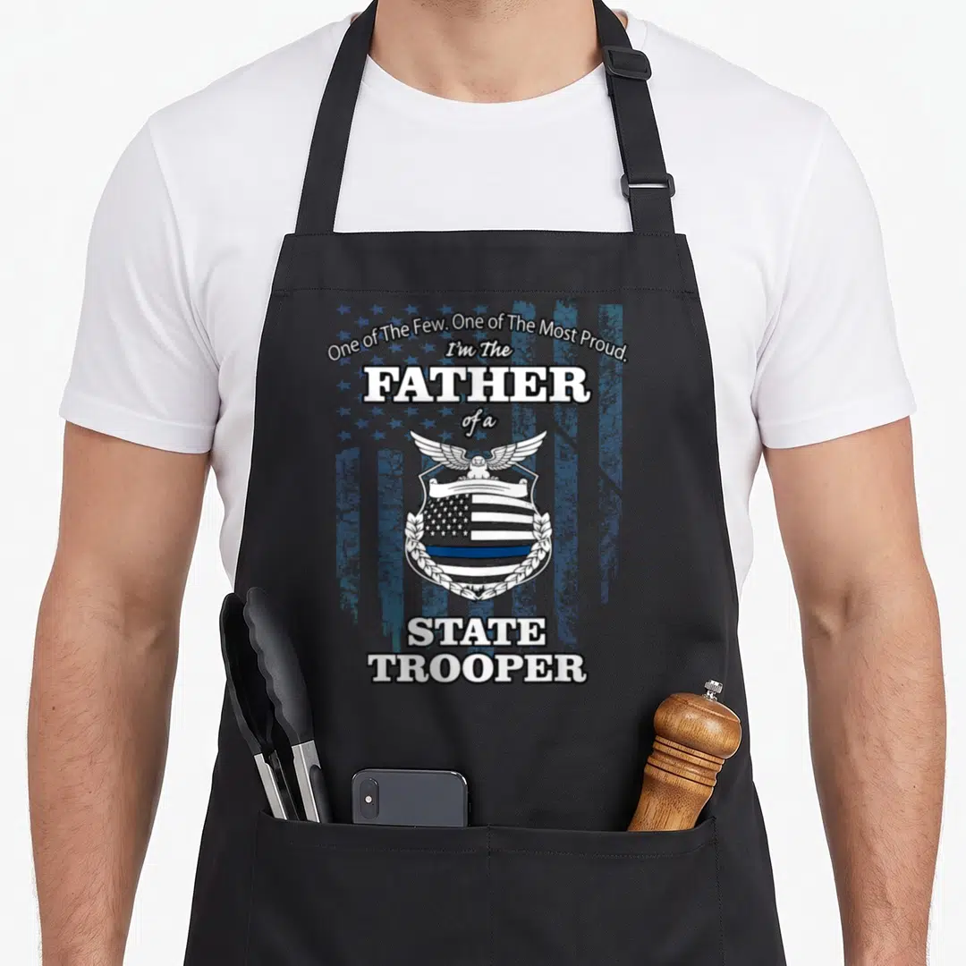 Badge police apron - Distressed badge with eagle and flag reading One of The Few One of The Most Proud I'm The Father — shown on a black cotton canvas apron against a white background