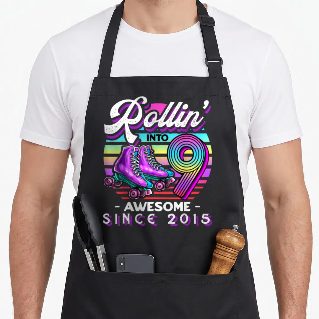Roller skating birthday apron - Retro roller skates and rainbow number 9 with text Rollin into 9 Awesome Since 2015 — shown on a black cotton canvas apron against a white background