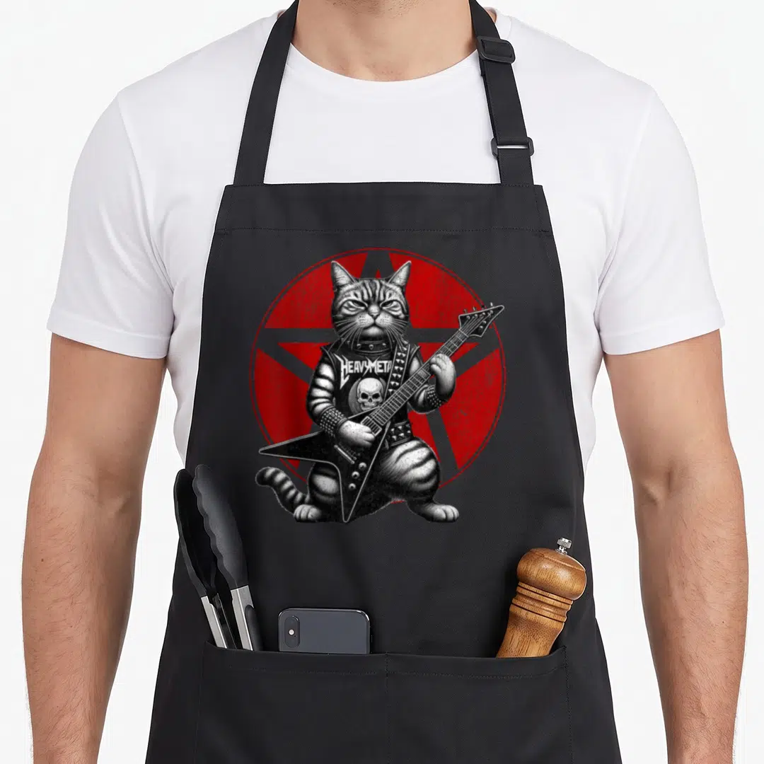 Death heavy metal apron - Realistic grey cat playing guitar in front of red pentagram with studded vest text — shown on a black cotton canvas apron against a white background