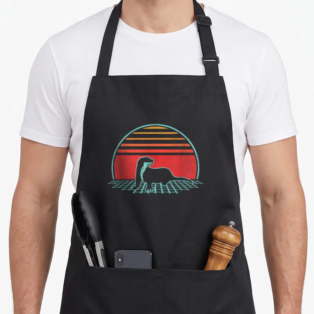 Otter animal apron - Otter silhouette on blue grid under striped red-orange-yellow sun in retro style — shown on a black cotton canvas apron against a white background