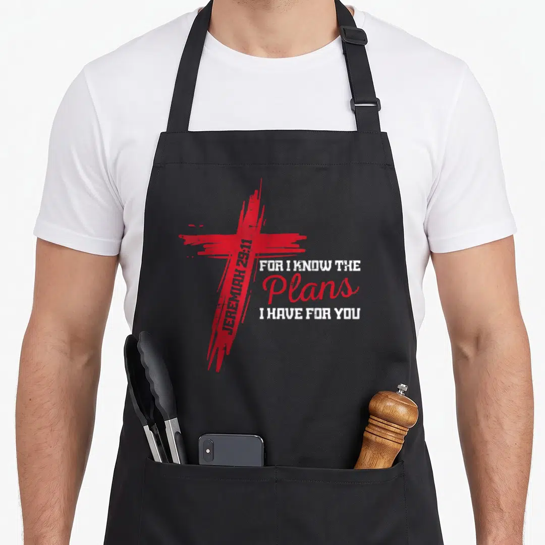 Plan god christian apron - Red distressed cross with vertical JEREMIAH 29:11 text and stacked For I Know The Plans I — shown on a black cotton canvas apron against a white background