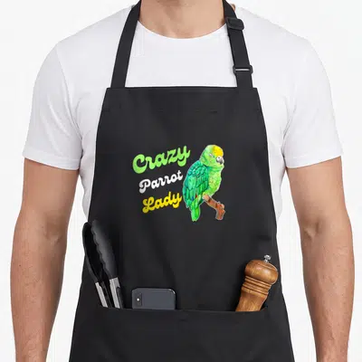 Parrot owner bird apron - Stacked Crazy Parrot Lady text beside perched green parrot in cartoon watercolor style — shown on a black cotton canvas apron against a white background