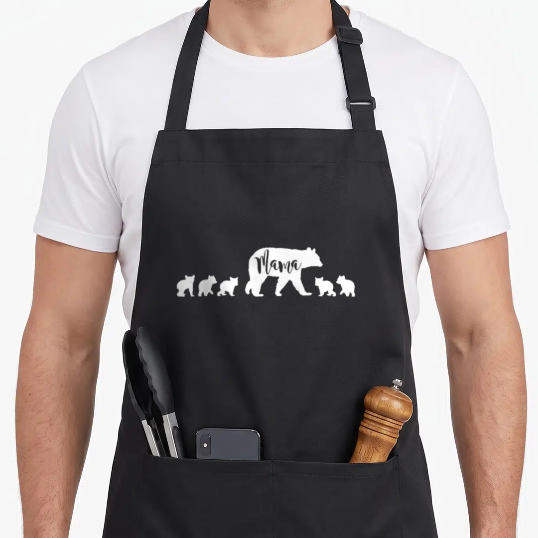 Five cute bear apron - White Mama bear silhouette with five cubs and text cutout — shown on a black cotton canvas apron against a white background