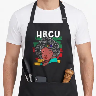 Funny hbcu historical aprons - Typographic woman portrait with HBCU text and affirming words forming hair in white red — shown on a black cotton canvas apron against a white background