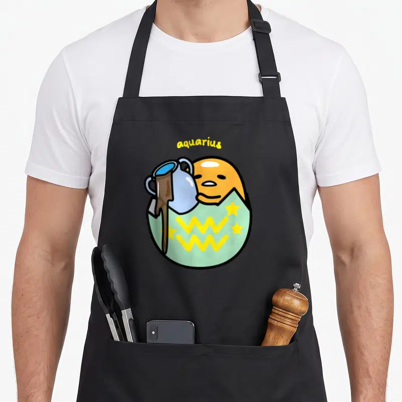 Aquarius gudetama apron - Orange egg face holding blue pitcher pouring brown liquid over mint green shape with yellow — shown on a black cotton canvas apron against a white background