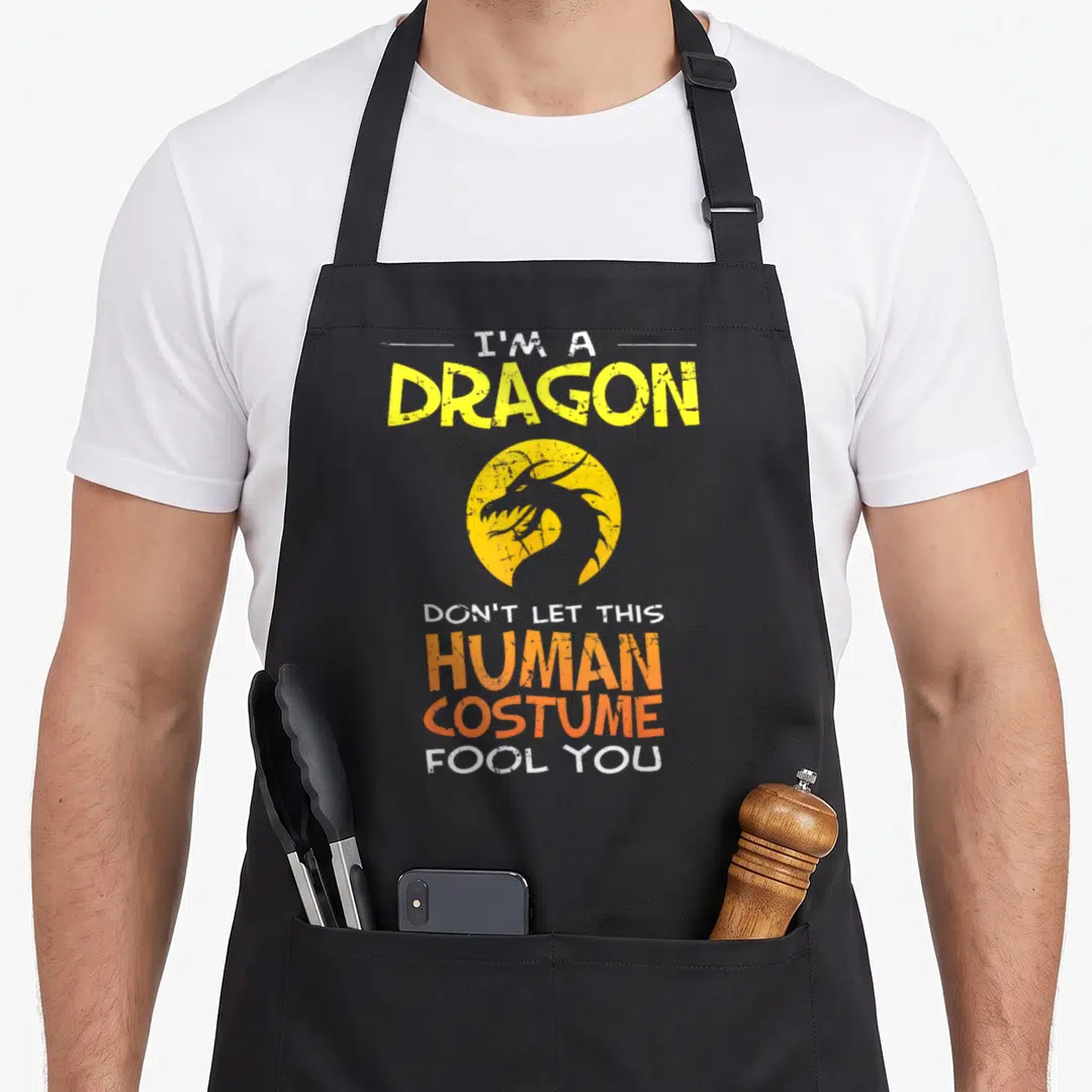 Fool dragon apron - Distressed yellow dragon circle with I'M A DRAGON HUMAN COSTUME text — shown on a black cotton canvas apron against a white background