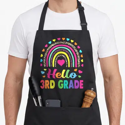 Hello leopard aprons - Rainbow with leopard print bands and pink heart above Hello 3rd Grade text — shown on a black cotton canvas apron against a white background