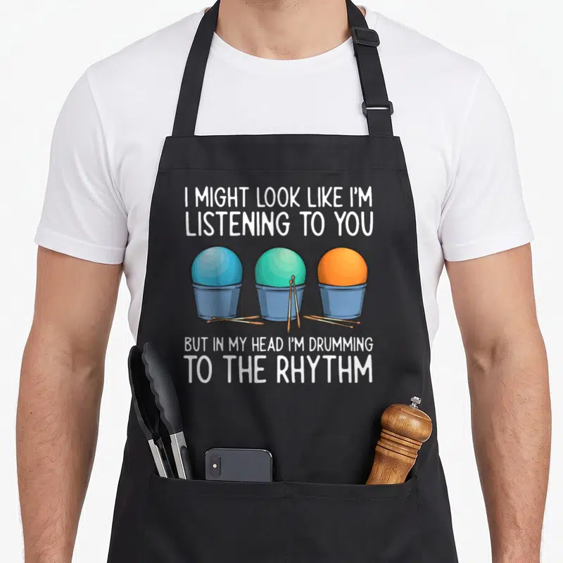 Cardio i love drums apron - Three colored buckets with sticks and text about drumming internally — shown on a black cotton canvas apron against a white background