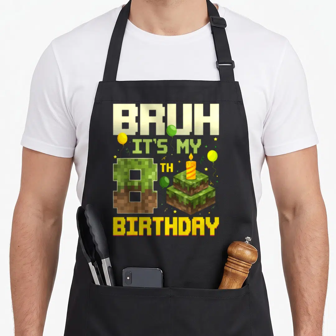 8th game birthday apron - Pixelated cake and number 8 with BRUH IT'S MY 8TH BIRTHDAY text and balloons in green — shown on a black cotton canvas apron against a white background