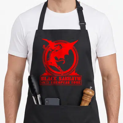 European black sabbath apron - Red demon in double ring with 1975 European Tour text box — shown on a black cotton canvas apron against a white background