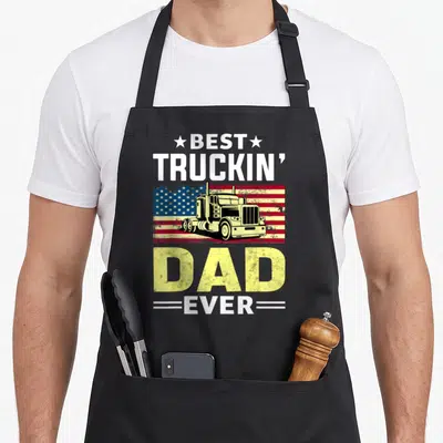 Trucking driver truck apron - Semi-truck on distressed flag with BEST TRUCKIN DAD EVER text and stars — shown on a black cotton canvas apron against a white background