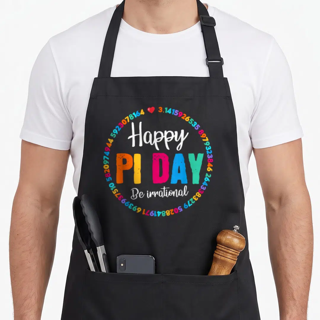 Pie teacher apron - Colorful Pi digits circle surrounding Happy PI DAY Be irrational text with red heart — shown on a black cotton canvas apron against a white background