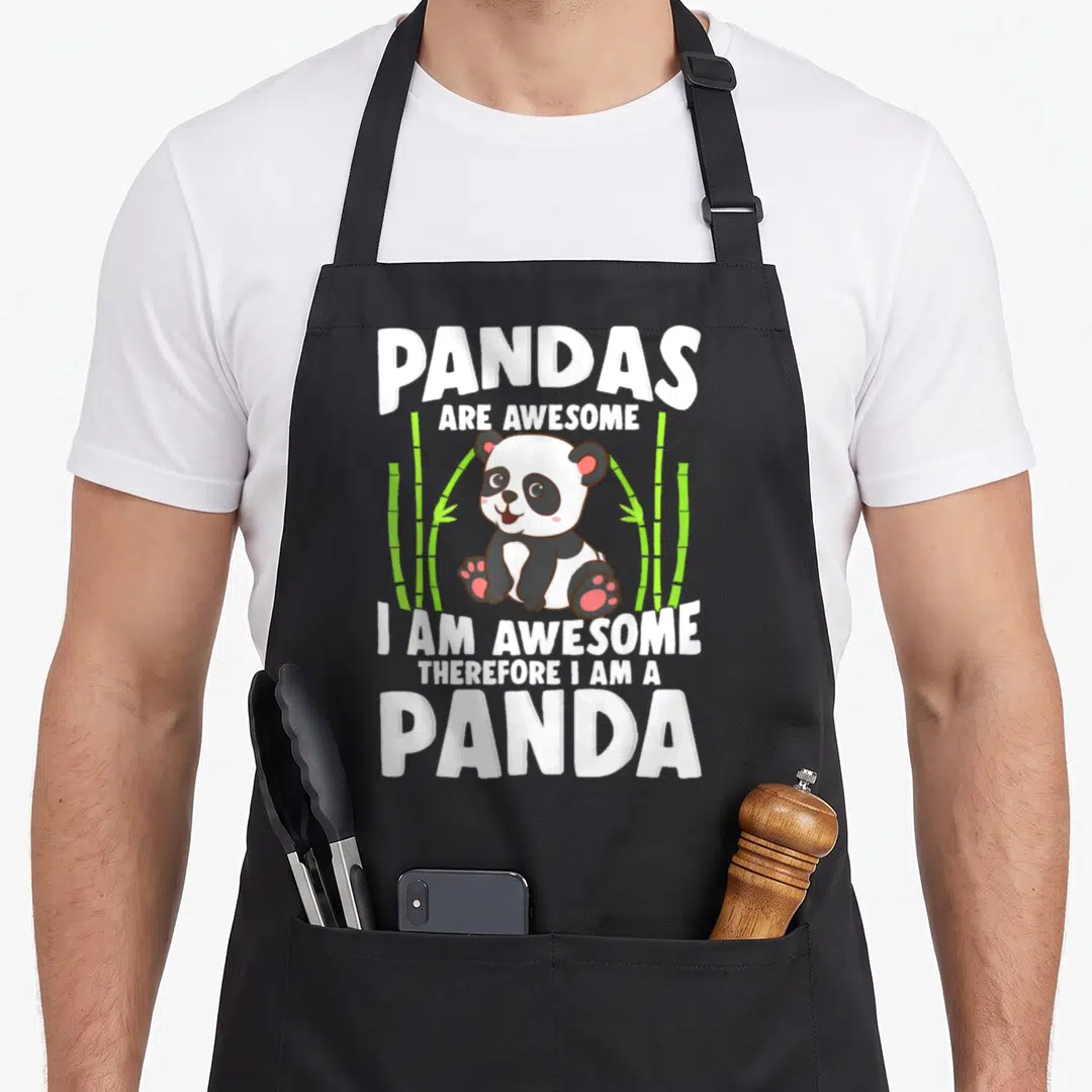 Panda bear apron - Cartoon panda sitting among green bamboo with text Pandas Are Awesome I Am Awesome Therefore I Am — shown on a black cotton canvas apron against a white background
