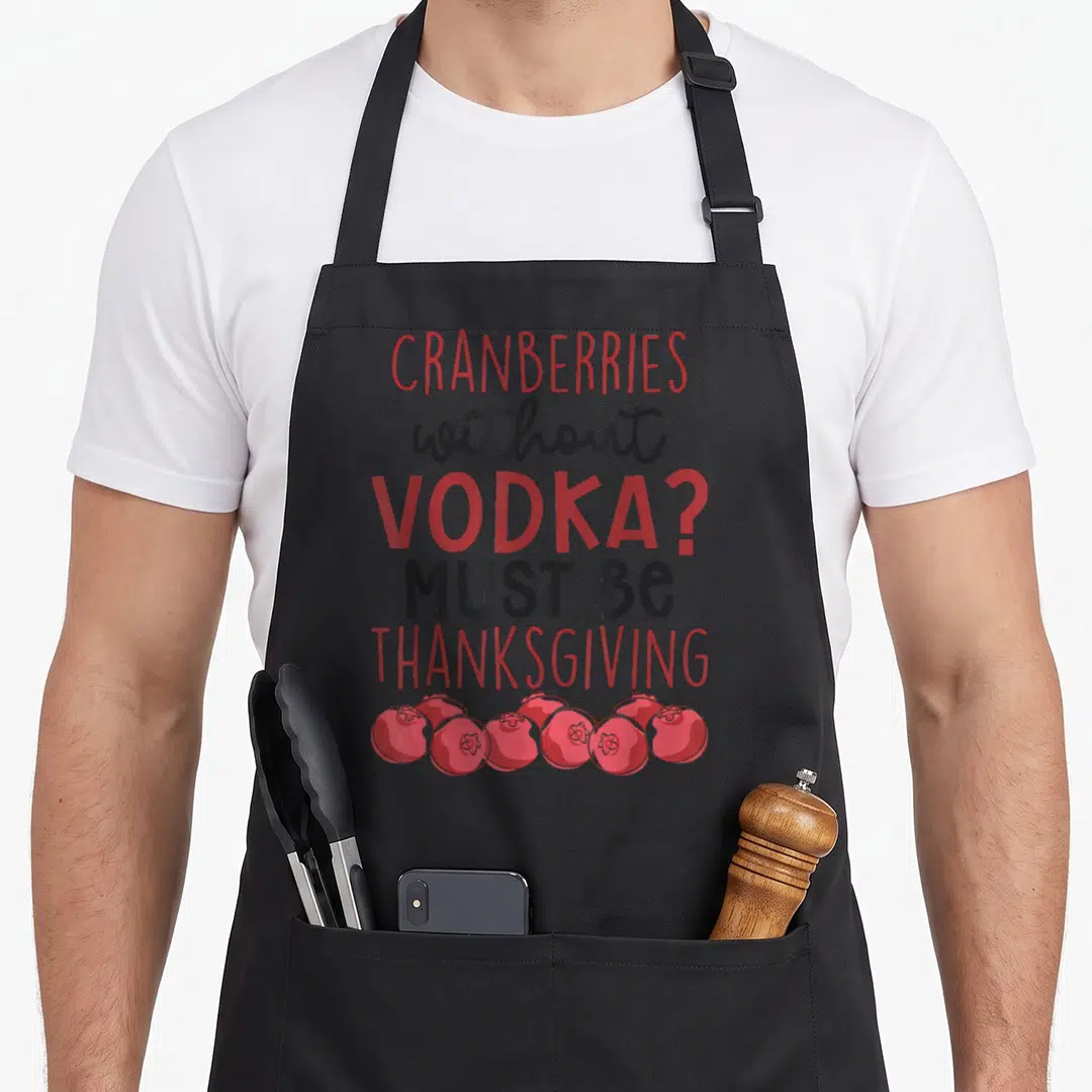 Vodka thanksgiving apron - CRANBERRIES without VODKA text with seven red berries at bottom — shown on a black cotton canvas apron against a white background