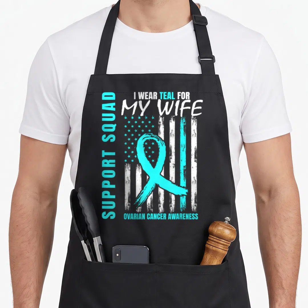 Support i love my wife apron - Teal ribbon and distressed flag with text supporting wife fighting ovarian cancer — shown on a black cotton canvas apron against a white background