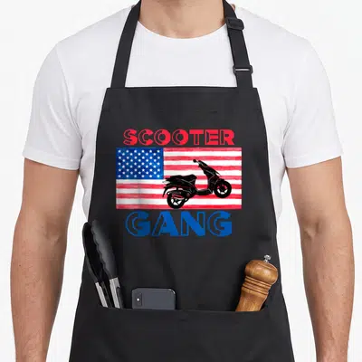 Scooter american flag apron - Black scooter silhouette over red white blue flag with SCOOTER GANG text — shown on a black cotton canvas apron against a white background
