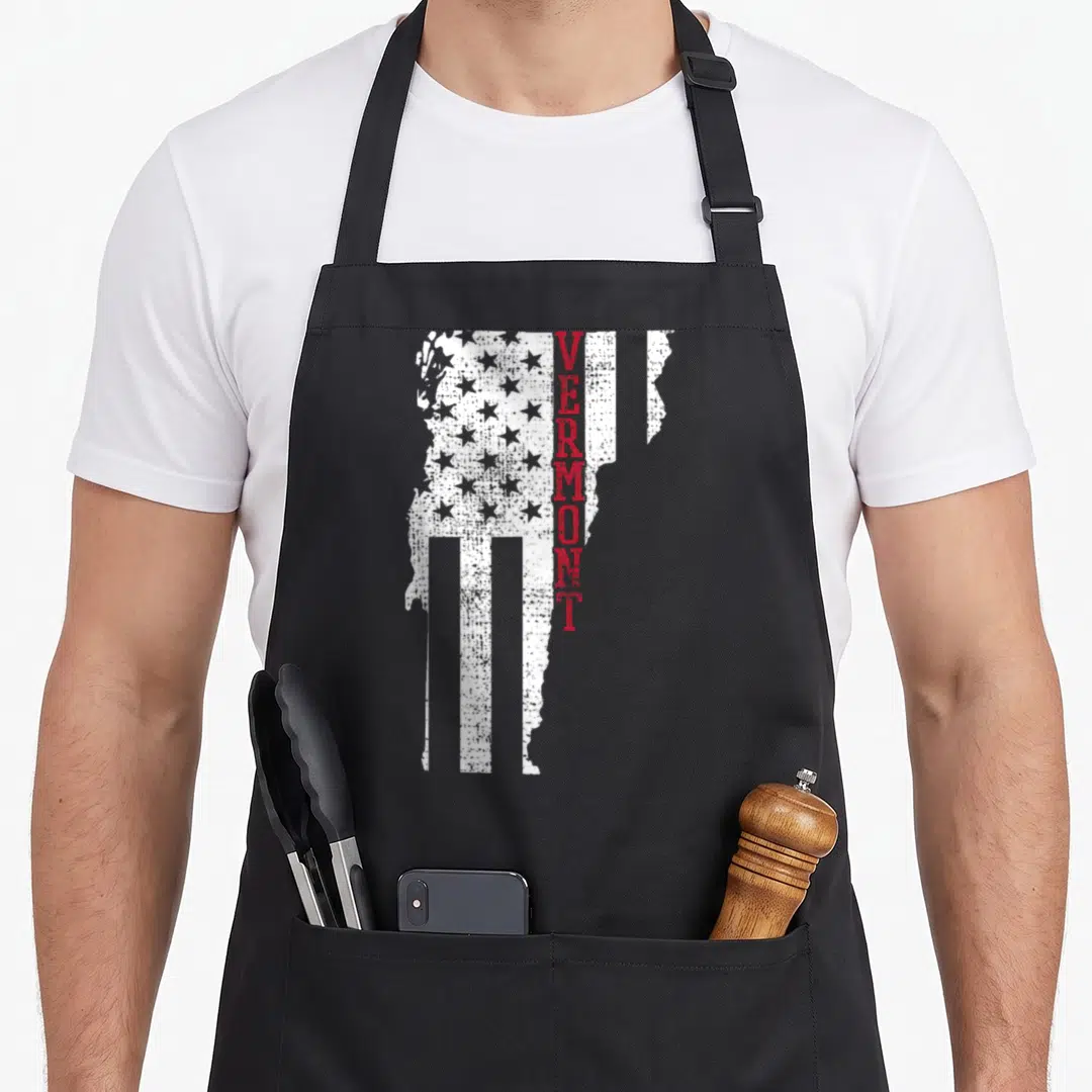 Flag vermont apron - Distressed white Vermont state map with red vertical text and star pattern — shown on a black cotton canvas apron against a white background
