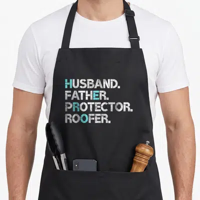 Husband roofing apron - White and blue text reading HUSBAND FATHER PROTECTOR ROOFER stacked vertically — shown on a black cotton canvas apron against a white background