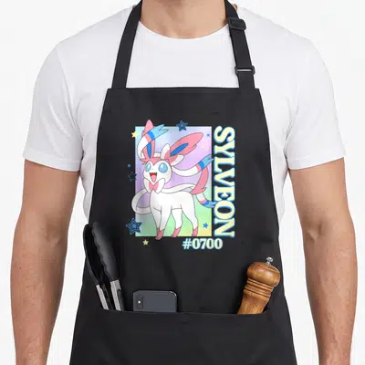 Sylveon colorful aprons - Sylveon #0700 cartoon on pink blue gradient with vertical text and stars — shown on a black cotton canvas apron against a white background