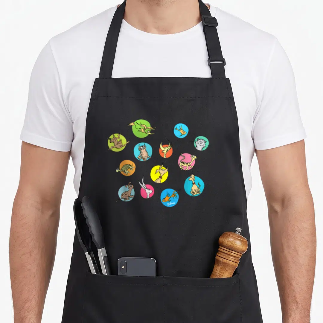Polka pet apron - Dr Seuss characters in yellow blue pink green orange circles with signature — shown on a black cotton canvas apron against a white background