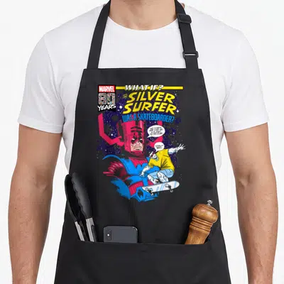 Surfer silver medal apron - Cartoon Silver Surfer on skateboard saying totally bro to Galactus — shown on a black cotton canvas apron against a white background