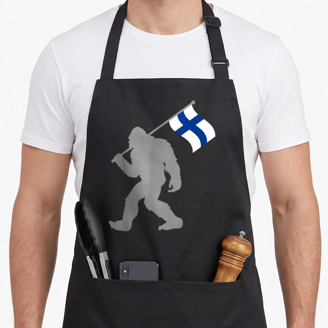 Suomi apron or apron - Grey Bigfoot silhouette walking holding a waving white and blue Finnish flag — shown on a black cotton canvas apron against a white background