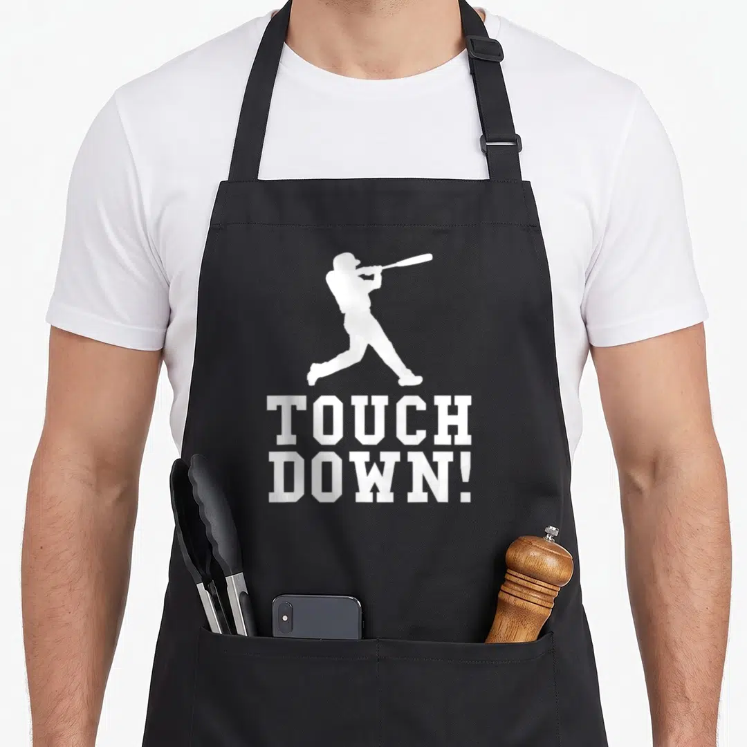 Touchdown football apron - White baseball batter silhouette above stacked text TOUCH DOWN! — shown on a black cotton canvas apron against a white background