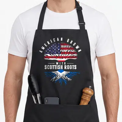 Grown scottish scotland apron - Tree with American flag leaves and Scottish saltire roots in distressed red white blue — shown on a black cotton canvas apron against a white background