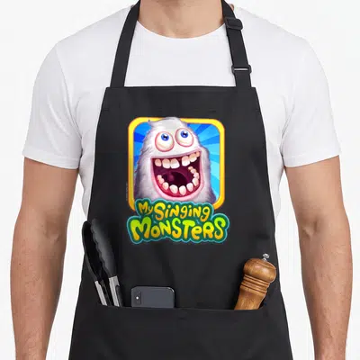 Mammott singing apron - White monster head in yellow blue frame with My Singing Monsters text — shown on a black cotton canvas apron against a white background